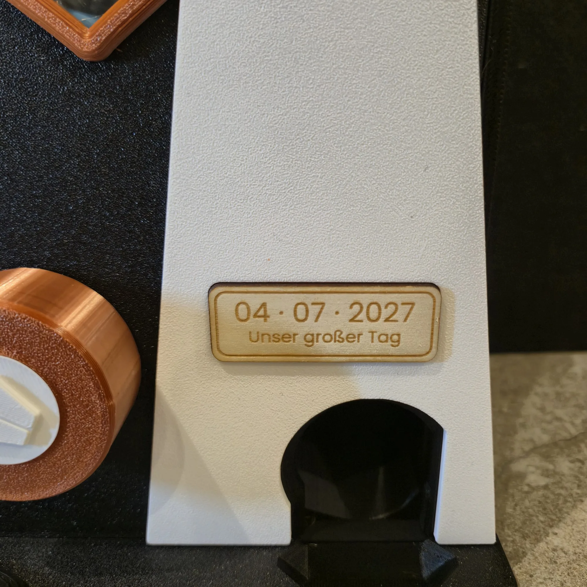 Graviertes Holzschild mit Datum 04 · 07 · 2027 und „Unser großer Tag“ am Brautkleid