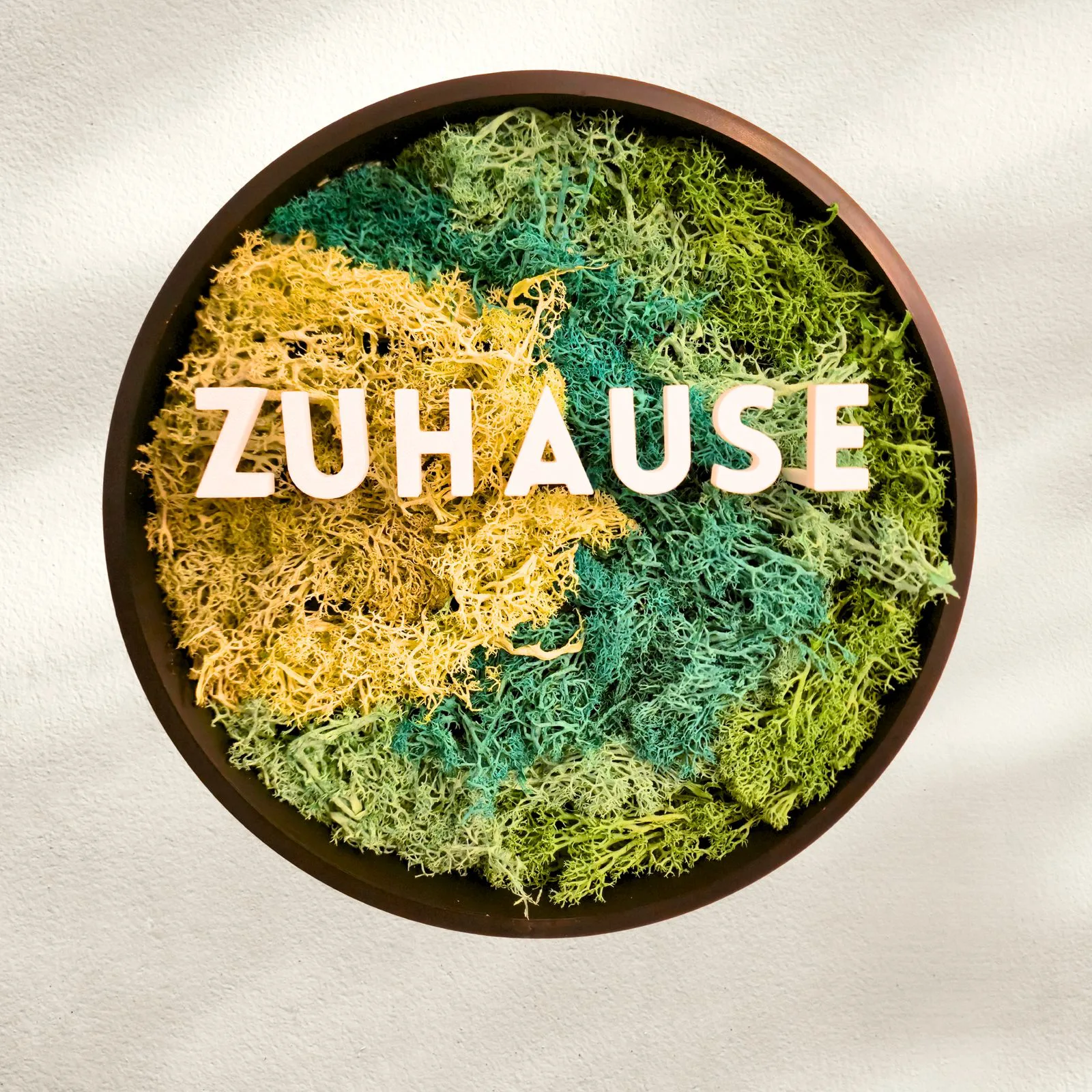 Moosbild rund mit weißen Buchstaben ZUHAUSE